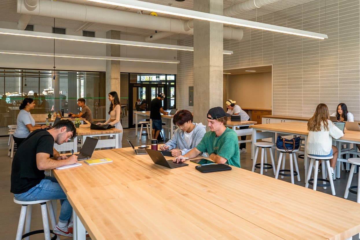 Students working together around shared tables in an entrepreneurship space.